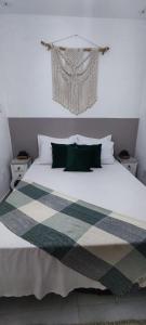 1 dormitorio con 1 cama blanca grande con almohadas verdes en Residencial suíte Arraial, en Arraial do Cabo