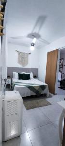 1 dormitorio con 1 cama y ventilador. en Residencial suíte Arraial, en Arraial do Cabo