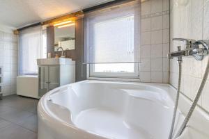 eine weiße Badewanne im Bad mit Fenster in der Unterkunft Sassnitz - Ferienwohnung 3 im Appartementhaus Hafenriff in Sassnitz
