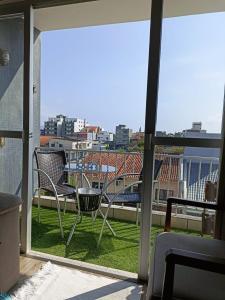 balcón con sillas y vistas a la ciudad en Praia da Enseada - apto 3 quartos - a 100m da Praia da Enseada e a 300m da Prainha! en São Francisco do Sul