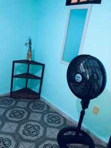 un ventilador en una habitación con una pared azul en Pousada Biribiri, en Salvador
