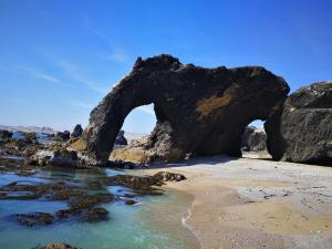 un arco en las rocas en la playa en HOTEL D'PIERO MARCONA, en San Juan