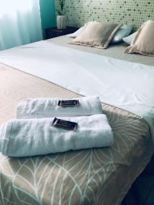 un par de toallas sentadas en una cama en Pousada Biribiri, en Salvador