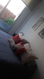 1 dormitorio con cama con almohadas y ventana en Moderno departamento con balcón en Recoleta en Buenos Aires