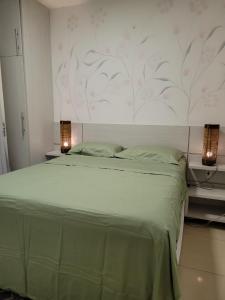 1 dormitorio con 1 cama grande con 2 luces. en Vila Mulungu Casa, en Mulungu