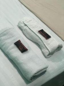 dos toallas blancas están sentadas en una cama en Pousada Biribiri, en Salvador