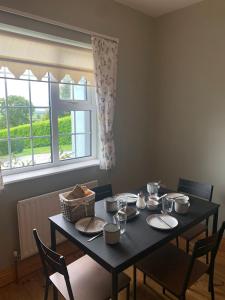 a dining room table with chairs and a window at Garrenmore Lodge B&B in Tipperary