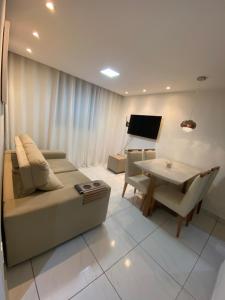 a living room with a couch and a table at Praia de jangada 103 - barra de jangada recife in Recife