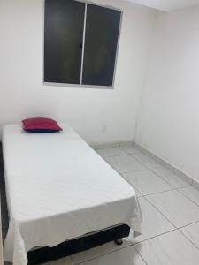 a bedroom with a bed with a red pillow on it at Praia de jangada 103 - barra de jangada recife in Recife +3 photos