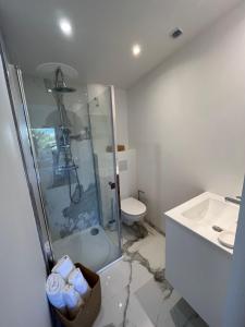 a bathroom with a shower and a toilet and a sink at Home Place Apartments - Gujan Arcachon in Gujan-Mestras