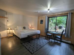 1 dormitorio con cama, mesa y ventana en Jade Resort-Oceanfront Suites in Gowlland Harbour en Heriot Bay