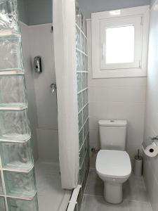 uma casa de banho branca com um WC e uma janela em ATALAYA DEL RÍO em Valderrobres