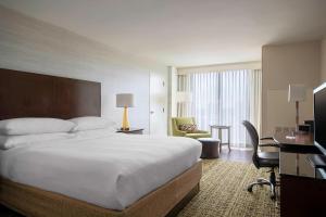アトランタにあるアトランタ マリオット ペリメター センターの大きなベッドとデスクが備わるホテルルームです。