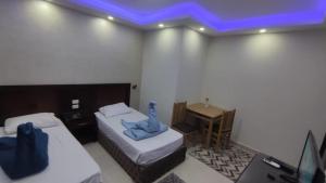 a room with two beds and a desk with a blue light at Lillyland Mirage Bay & Aqua Park in Hurghada