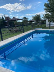 una piscina azul con una mesa de picnic en el fondo en Los Talares en Baradero