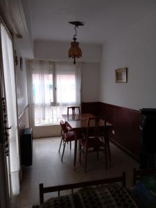 ein Esszimmer mit einem Tisch, Stühlen und einem Fenster in der Unterkunft 8C Departamento con Vista al Mar in Mar del Plata