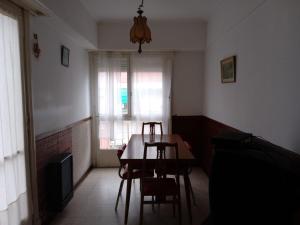 ein Esszimmer mit einem Tisch, Stühlen und einem Fenster in der Unterkunft 8C Departamento con Vista al Mar in Mar del Plata