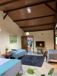 a room with two beds and a flat screen tv at Vila Verde Perto in Lençóis