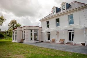 an exterior view of a white house at Mansion House Llansteffan in Carmarthen
