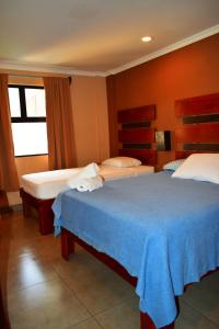 a hotel room with two beds and a window at Hotel Cabinas Midey in Puntarenas