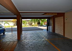 a building with a car parked in a parking lot at Hotel Cabinas Midey in Puntarenas