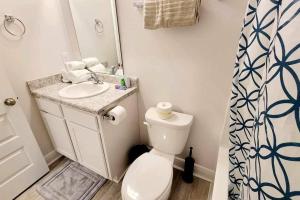 a bathroom with a toilet and a sink and a mirror at Brand NEW house in Pensacola EV connector included in Pensacola