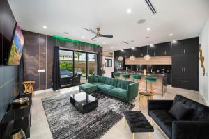 a living room with a green couch and a bar at The Elements Luxury Home Fort Lauderdale in Fort Lauderdale