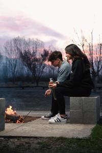 a man and a woman sitting next to a fire at Mahuida Lodge Valle de Uco in Colonia Las Rosas