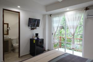 a bedroom with a bed and a large window at Solez Zihuatanejo in Zihuatanejo