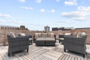 a patio with wicker chairs and a couch on a roof at NEW Downtown Modern Escape -The Lyric l King Bed l Gym l City View l Park FREE in Birmingham