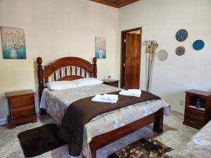 a bedroom with a bed with two towels on it at Pousada Pedacinho do Ceu - suite Anali 5 in Cunha