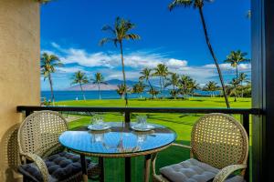 uma mesa e cadeiras numa varanda com vista para o oceano em Enjoy Your Oceanside Dream at Kihei Surfside em Wailea