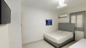 1 dormitorio pequeño con 1 cama y TV en apartamento Ana ciudad amurallada en Cartagena de Indias
