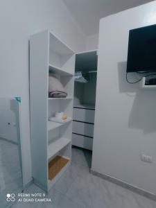 Angello في ليما: غرفة بيضاء مع سرير وتلفزيون