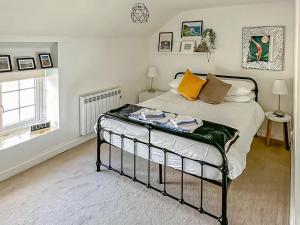 a bedroom with a bed and a window at Seren Cottage By The Sea in Bodorgan