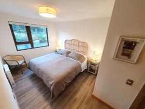 a bedroom with a large bed and a window at Acogedor Departamento a pasos del Lago Llanquihue in Puerto Varas