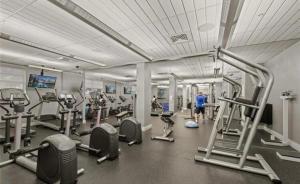 a gym with several tread machines and people in it at Tides Condominiums in Hollywood