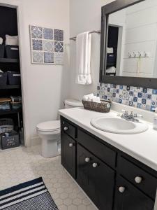 a bathroom with a sink and a toilet and a mirror at Wilmington Family Vacation Home in Wilmington