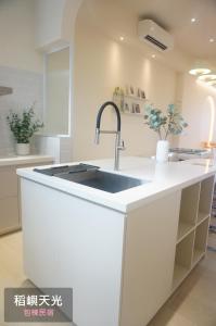 a kitchen with a sink in a white kitchen at 稻嶼天光包棟民宿 in Yilan City