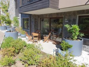 a patio with chairs and plants in front of a house at Acogedor Departamento a pasos del Lago Llanquihue in Puerto Varas +2 photos