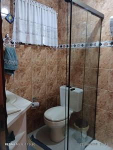 La salle de bains est pourvue d'une douche et de toilettes. dans l'établissement Suites e Quartos em casa, à Foz do Iguaçu