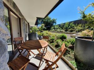 a patio with a table and chairs on a balcony at Acogedor Departamento a pasos del Lago Llanquihue in Puerto Varas