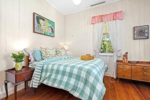 a bedroom with a green and white bed and a window at Buderim Milne House in Buderim