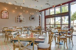 un restaurant avec des tables et des chaises en bois ainsi que des fenêtres dans l'établissement GORGEOUS - Luxurious 4 bedroom House 10 min drive to Disney World, à Orlando