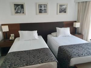 a hotel room with two beds and a telephone at Flat Beach Class Internacional in Recife