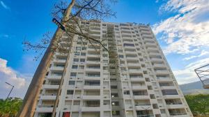 a tall white building with a tree at Santa fe de Antioquia apartamento vacacional di sole 1306 in Santa Fe de Antioquia
