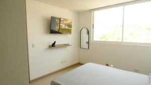 een witte kamer met een bed en een raam bij Santa fe de Antioquia apartamento vacacional di sole 1306 in Santa Fe de Antioquia