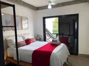 a bedroom with a bed with a red blanket on it at Uai House com jacuzzi (Espaço romântico) in Poços de Caldas