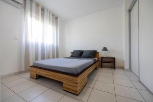 a bedroom with a bed in a white room at Wayana - DestinationGuyane - séjours en famille personnalisé in Cabassou