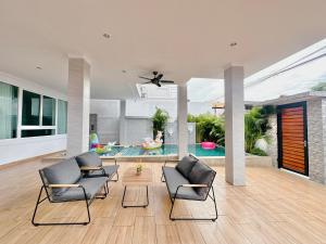 a living room with two chairs and a pool at Rosewood Pool Villa Pattaya 3 in Pattaya South